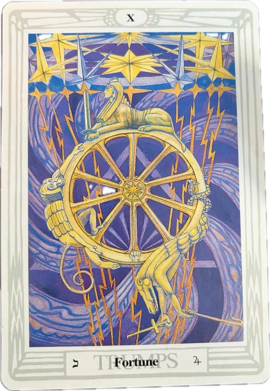 Thoth Tarot Fortune card, the Wheel of Fortune, showing a golden wheel with symbolic figures, yellow stars and lightning against a purple background.