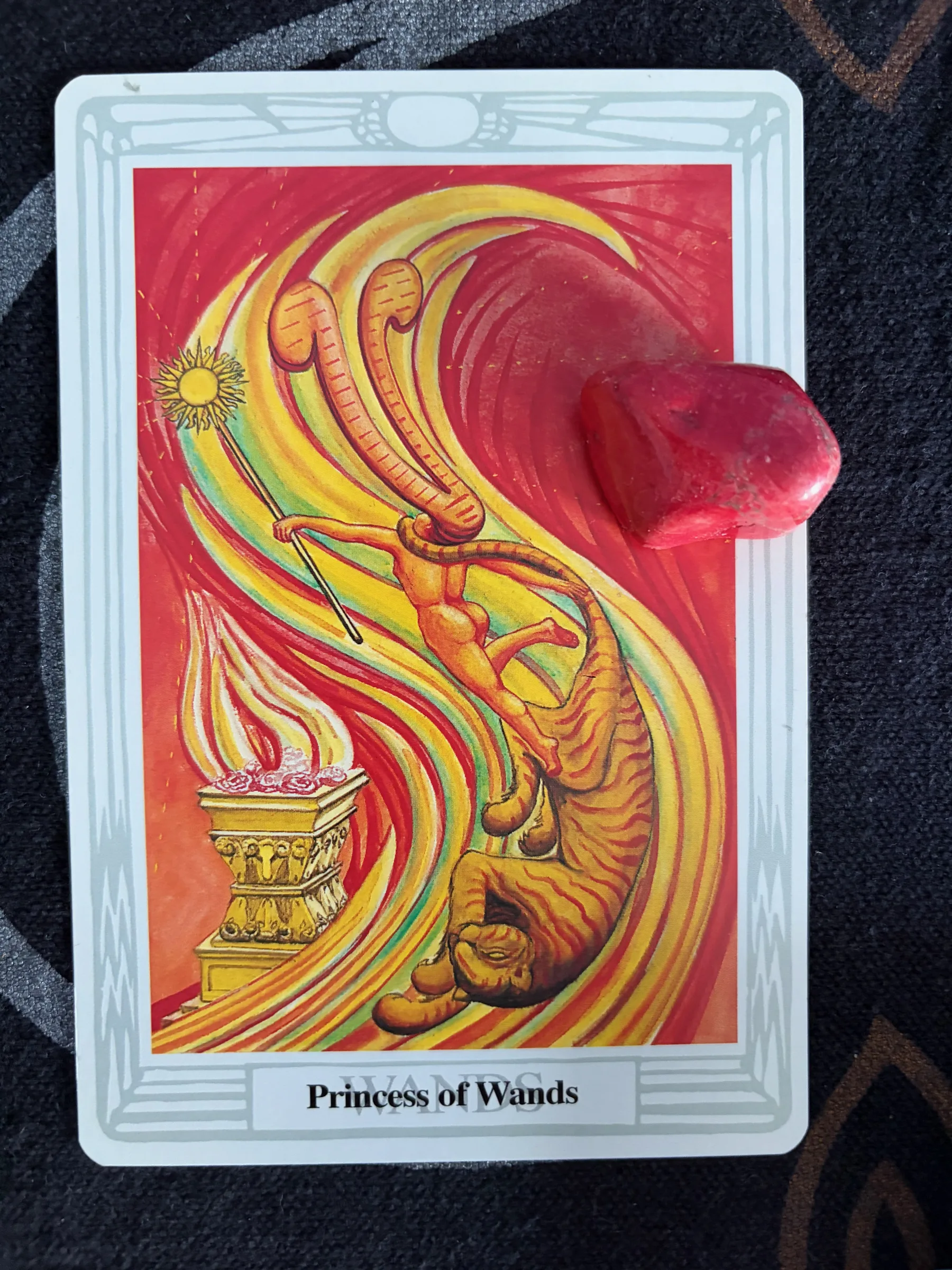 Princess of Wands Thoth Tarot card with a dancing figure, tiger, golden flames, and red crystal